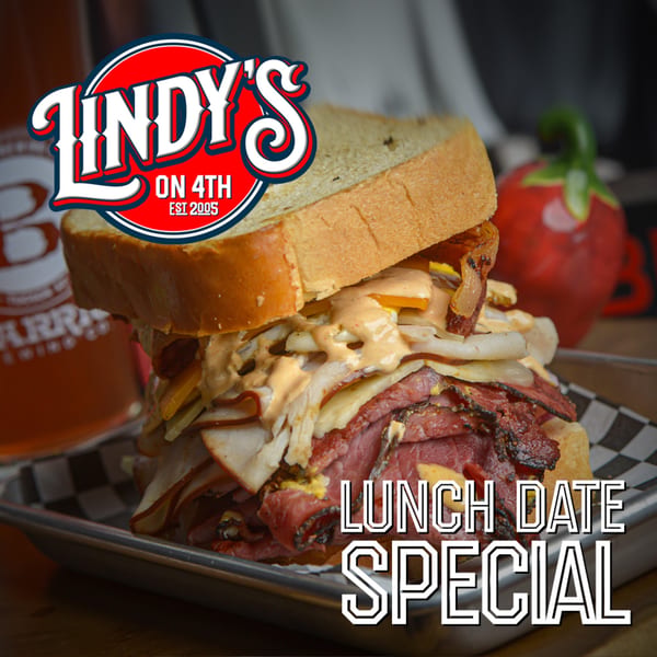 A towering pastrami sandwich with sauce and onions on a metal tray, with the Lindy's on 4th logo.