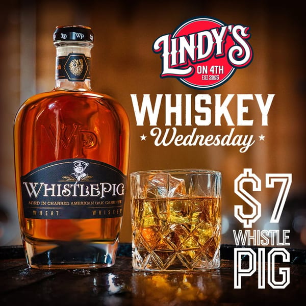 A bottle of WhistlePig whiskey next to a glass of whiskey on ice, advertising "Whiskey Wednesday" for $7.