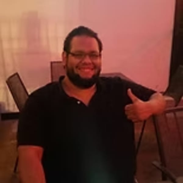 Smiling man with glasses and beard giving a thumbs up at Lindy's on 4th.